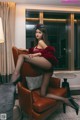 A woman sitting on a brown leather chair in a room.