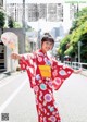 A woman in a red kimono holding a fan.