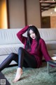 A woman sitting on the floor in a living room.