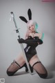 A woman in a bunny costume holding a sword.