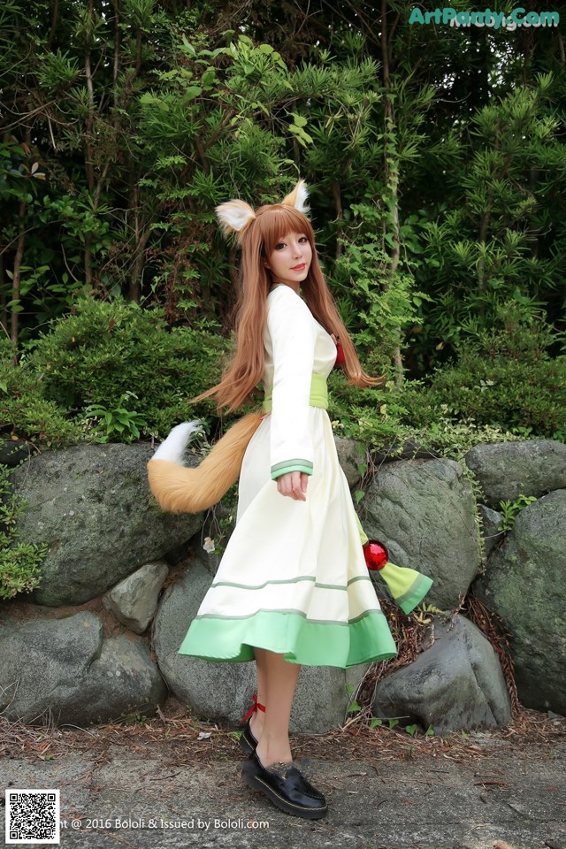 A woman in a white and green dress with a fox tail.