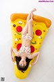 A woman laying on an inflatable pizza slice.