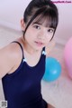 A young girl in a blue leotard sitting on the floor.