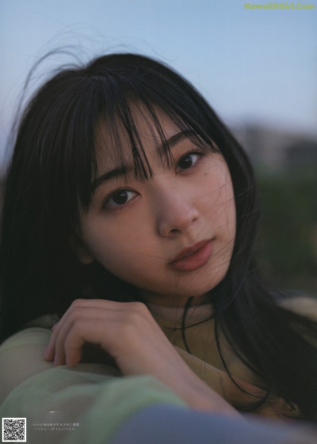 A woman with long black hair is posing for a picture.