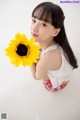 A young girl holding a sunflower in her hand.