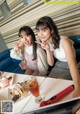 Two young women sitting at a table with a laptop.