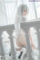 A woman in a white lingerie sitting on a table.