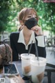 A woman sitting at a table with a cup of coffee.