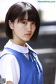 A young woman in a blue and white school uniform.