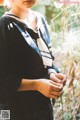 A woman in a school uniform standing in the woods.