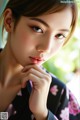 A woman in a black and pink kimono posing for a picture.