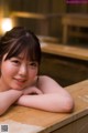 A woman laying on top of a wooden table.