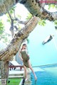 A woman in a green dress standing by a pool.