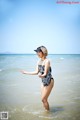 A woman in a bathing suit standing in the ocean.