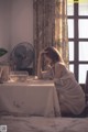 A woman sitting at a table in front of a window.