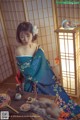 A woman in a blue kimono sitting on a table.