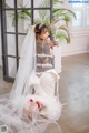 A woman in a wedding dress sitting on the floor.